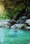 A person enjoying a refreshing cold plunge in a natural setting.