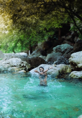 A person enjoying a refreshing cold plunge in a natural setting.