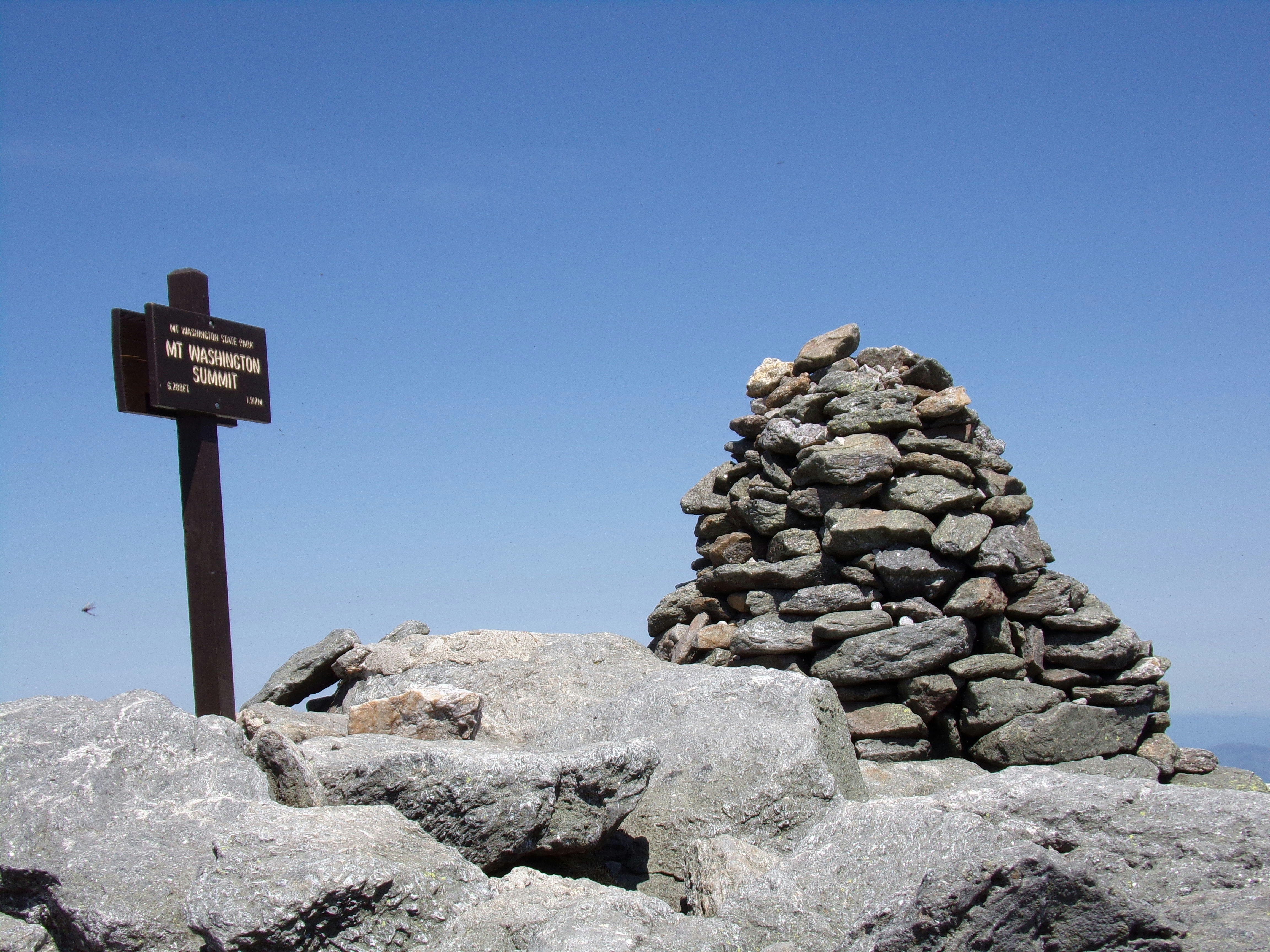 a sign on top of a large pile of rocks