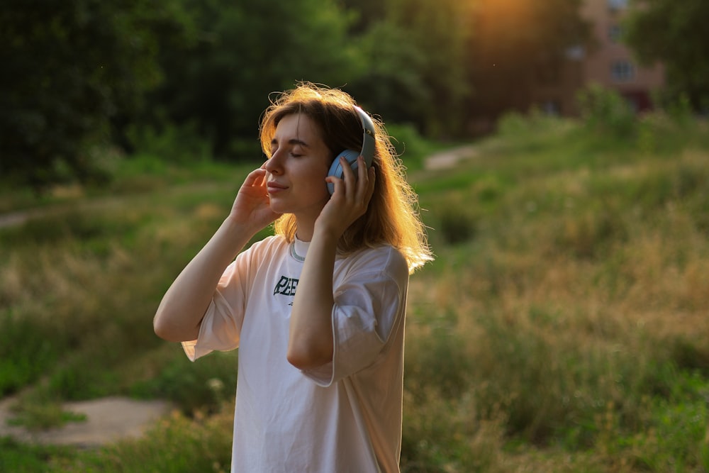 a woman talking on a cell phone while standing in a field