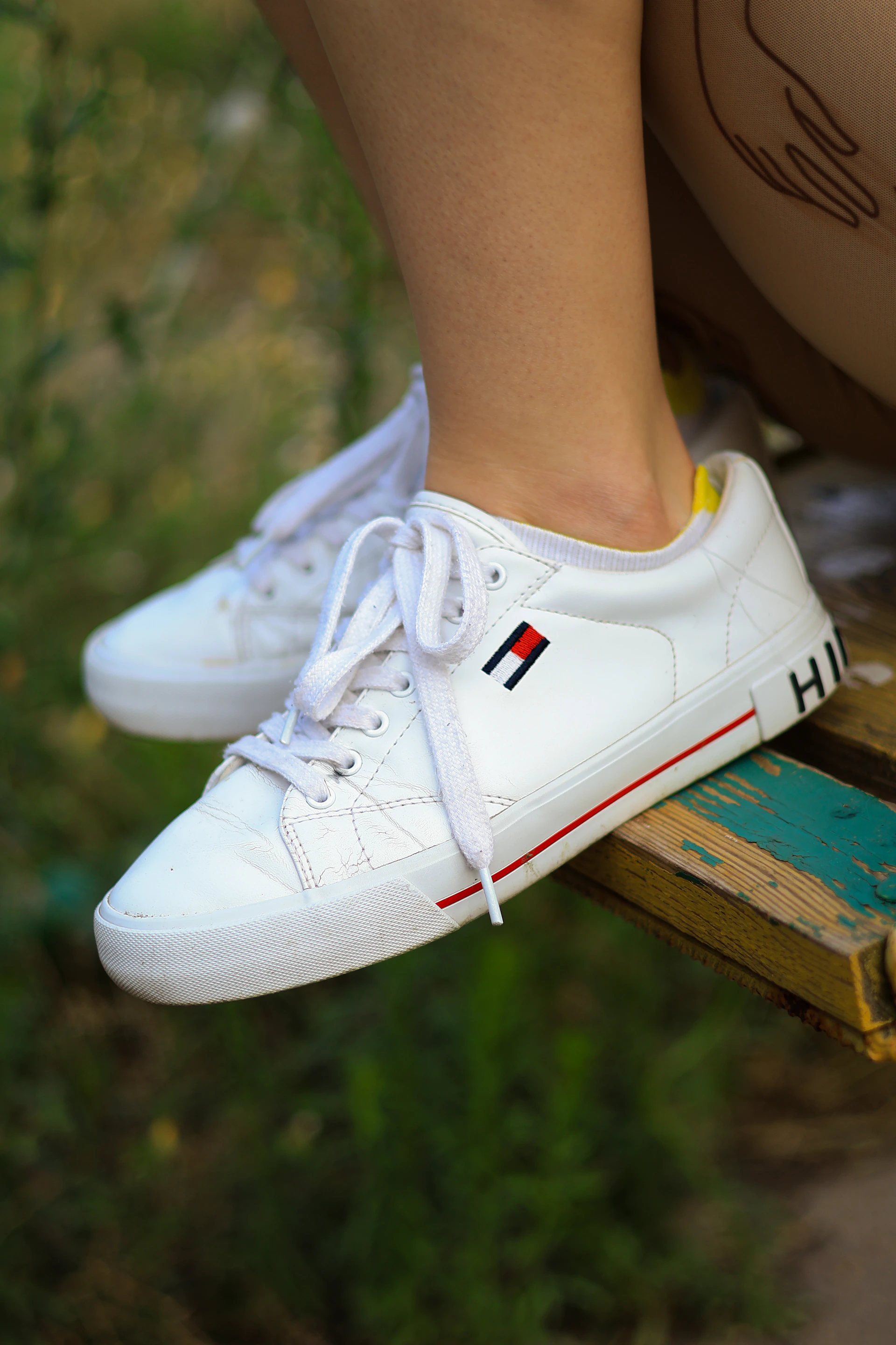 a close up of a person's white tennis shoes