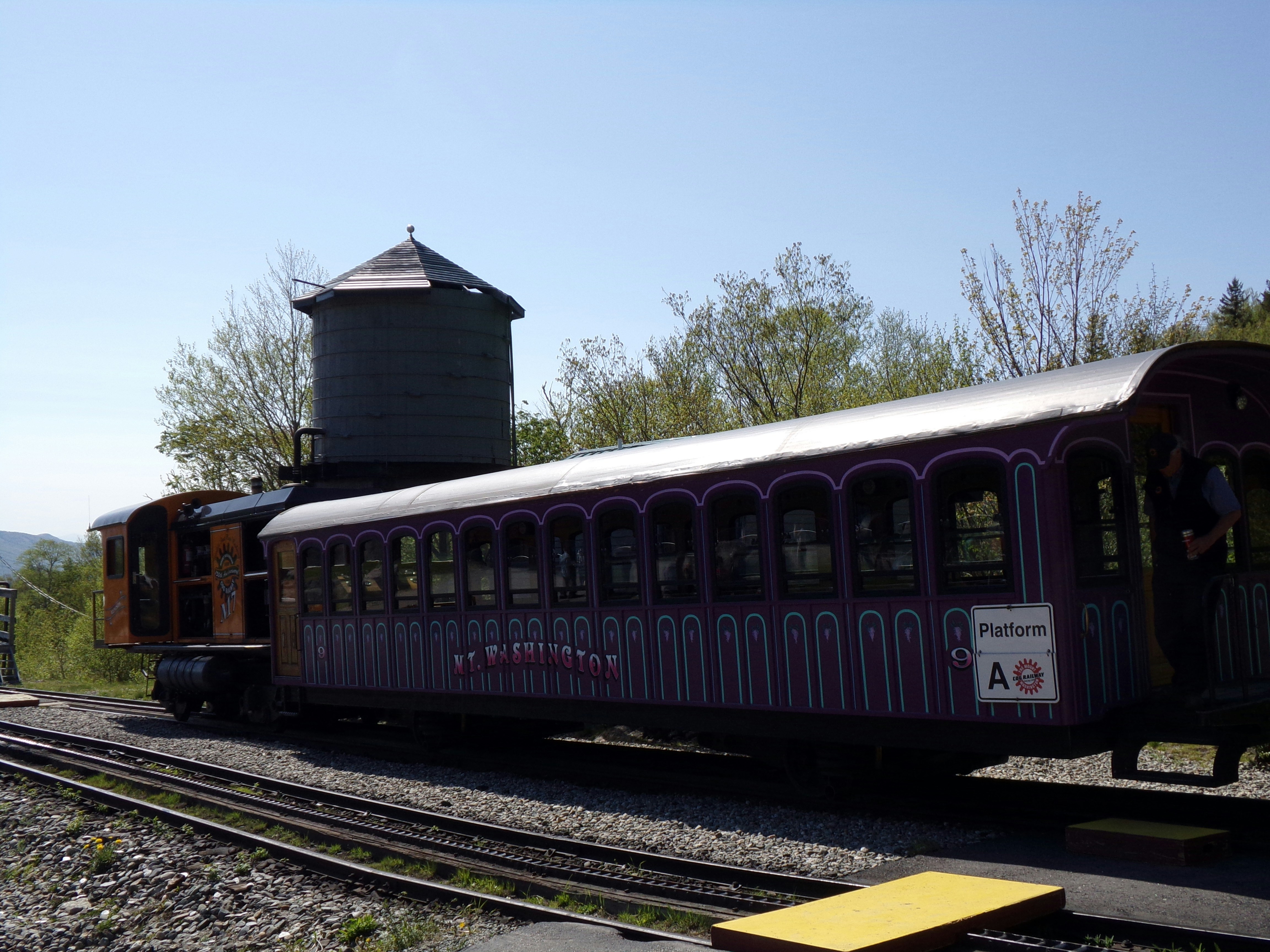 a train on the tracks with a water tower in the background