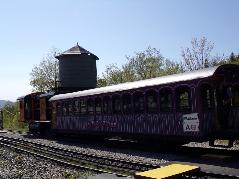 a train on the tracks with a water tower in the background