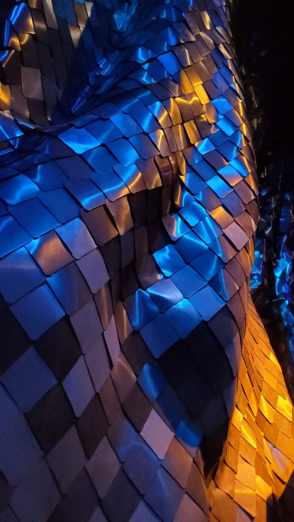 a close up of a shiny surface with blue and yellow lights