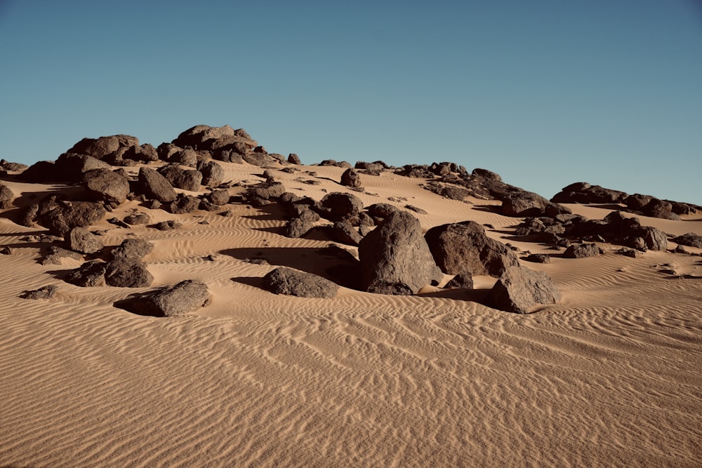 rocks and sand in the desert under a blue sky