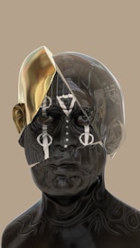 A digital artwork depicts a futuristic, abstract human face with metallic and glass textures. The left side of the head includes a shiny, gold-like surface, while the right side is transparent with visible internal structures. Intricate tribal or symbolic patterns cover the face, adding a mysterious and artistic element.