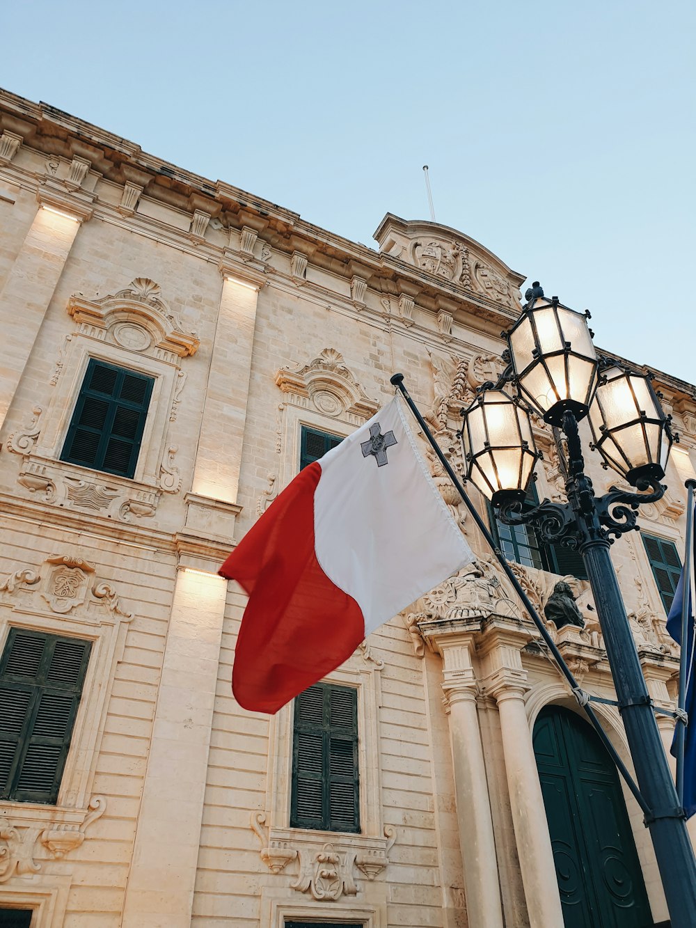 a flag hanging from a lamp post in front of a building