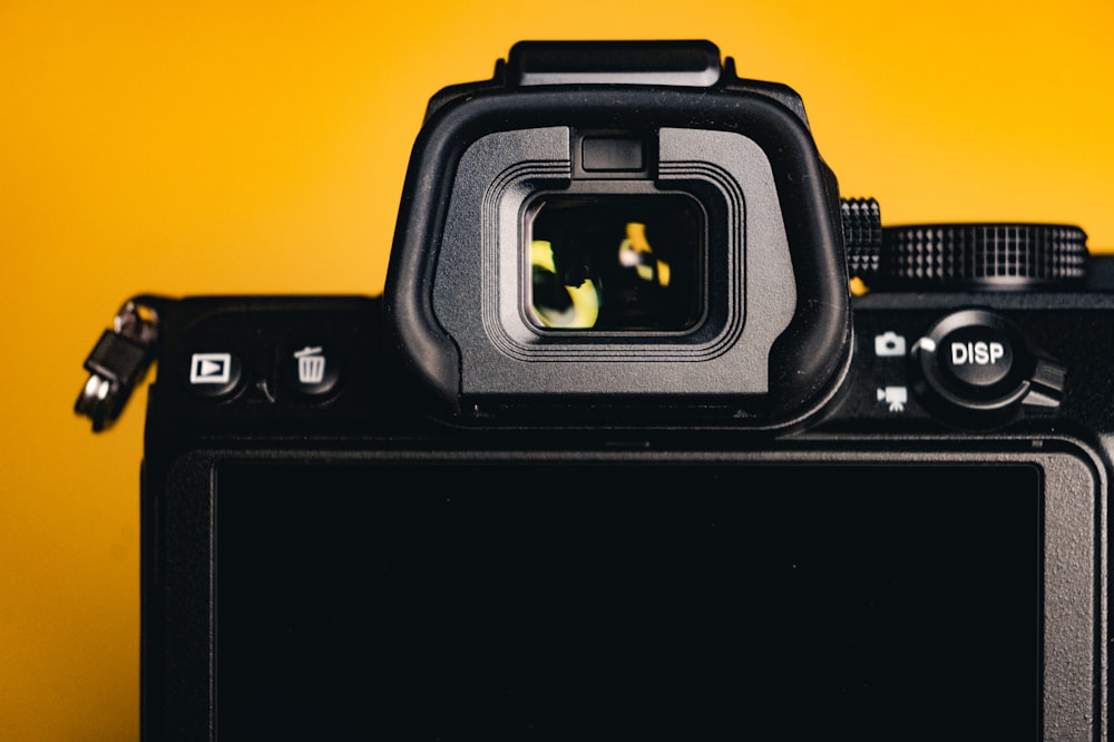 a close up of a camera with a yellow background