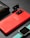 A vibrant red Samsung smartphone is placed on a dark textured surface, accompanied by a black leather wallet, a pair of black wireless earbuds, and a smartwatch with a turquoise band. The layout appears organized, showcasing a selection of modern electronic devices and personal accessories.