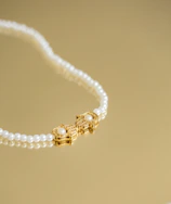 Bridal necklace featuring layered gold and diamond craftsmanship resting on ivory silk fabric.
