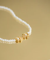 Rows of shimmering pearls resting gently in a champagne gold tray, ready for selection.