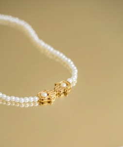 Close-up of a lustrous South Sea pearl necklace resting on soft ivory fabric with hints of gold and deep blue accents.