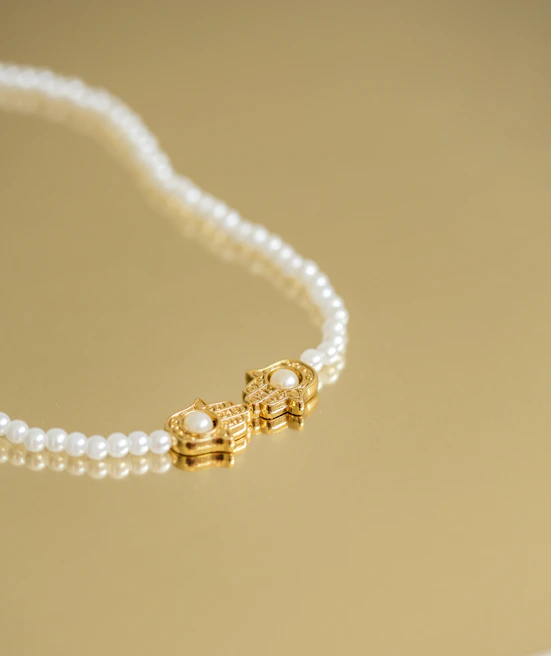 Elegant pearl necklace resting gracefully on a dark green silk fabric