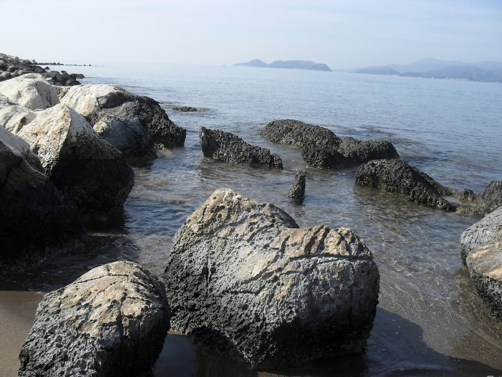 a rocky beach with large rocks in the water