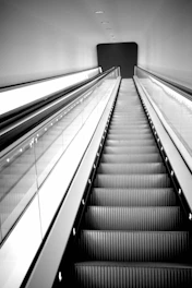 a black and white photo of an escalator