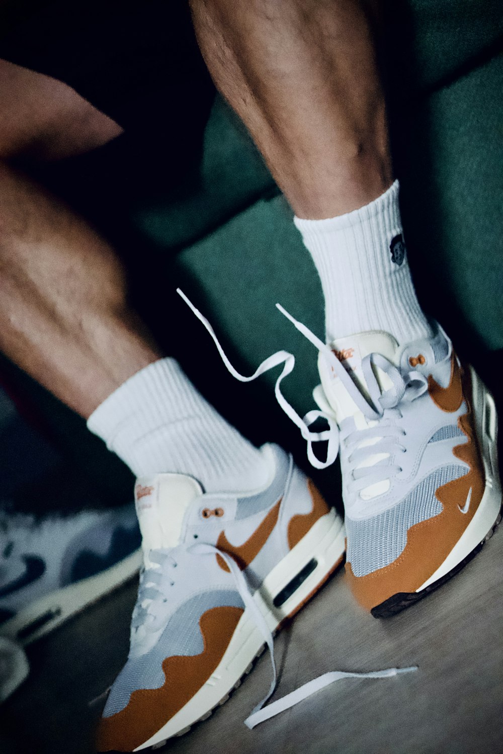 a close up of a person's feet wearing white and orange sneakers