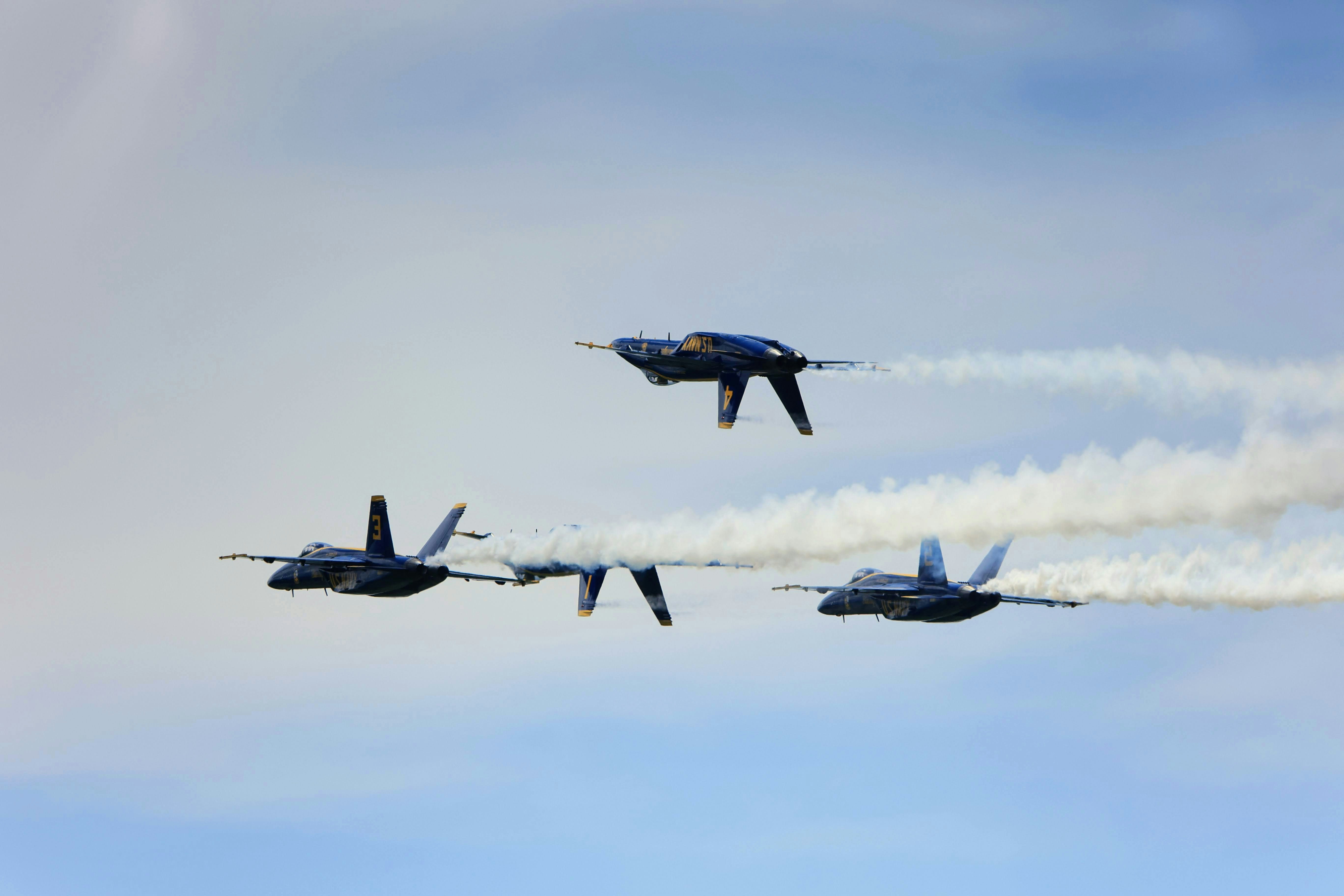 a group of planes flying through a blue sky