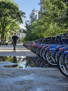 A friendly staff member helping a customer with bike rental near Central Park on a sunny day.