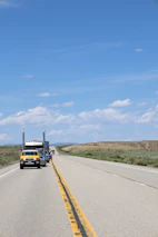 A long highway stretching into the horizon with a BlueHaul truck driving.