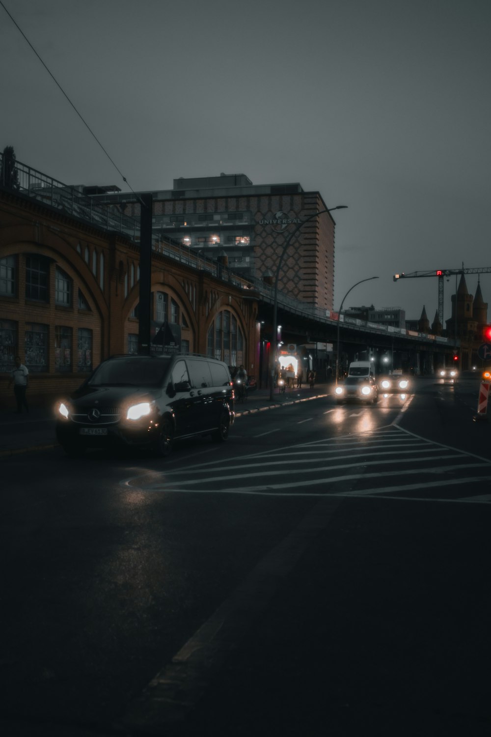 a city street at night with cars driving down it