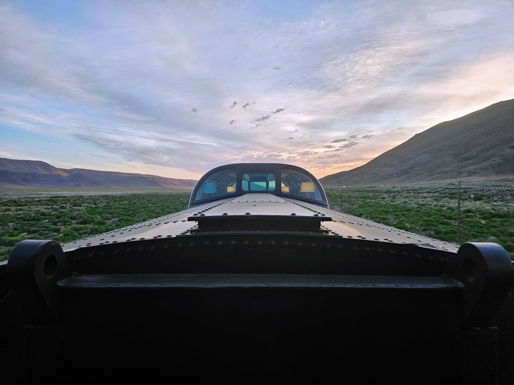 a view of the back end of a vehicle in a field