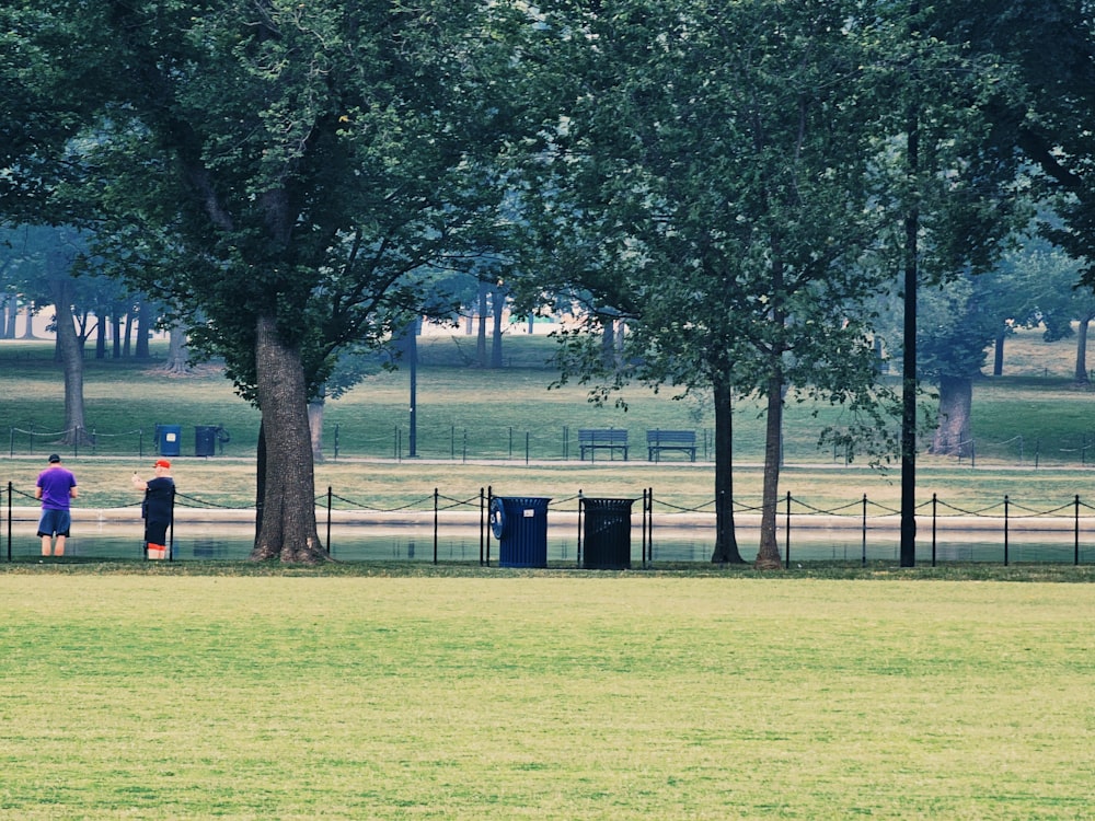 a couple of people standing next to each other on a lush green field