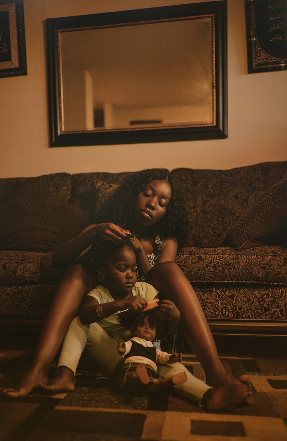 two women sitting on the floor in front of a couch