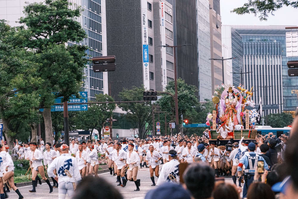 a group of people walking down a street next to tall buildings