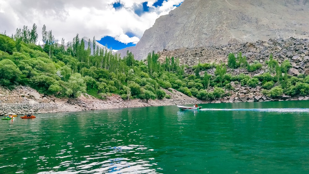 Un bateau descendant une rivière à côté d’une colline verdoyante