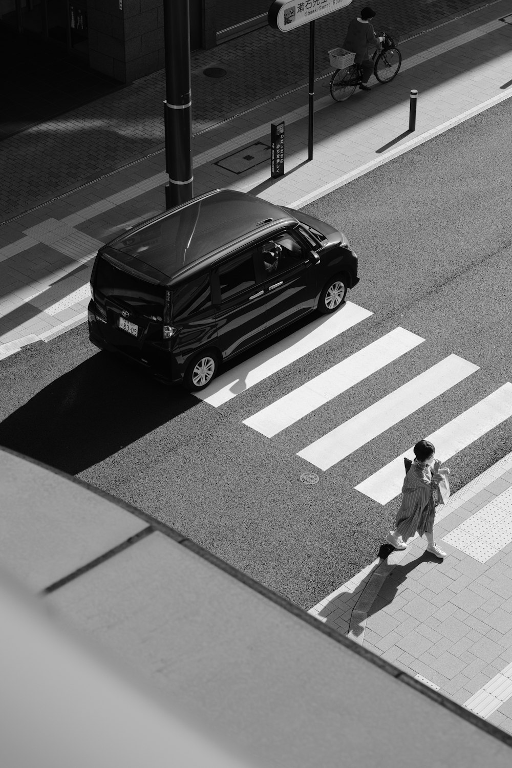 a person walking across a street next to a van