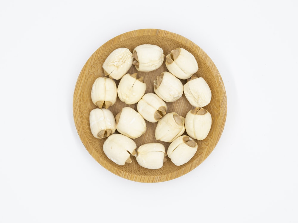 peeled bananas in a wooden bowl on a white background