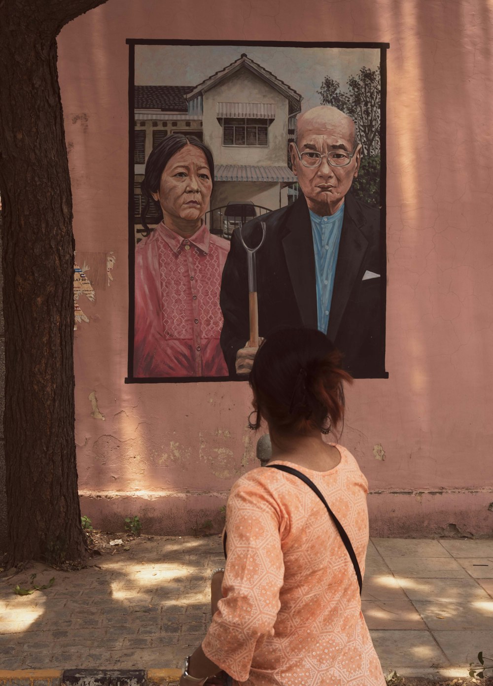a woman looking at a painting of a man and woman