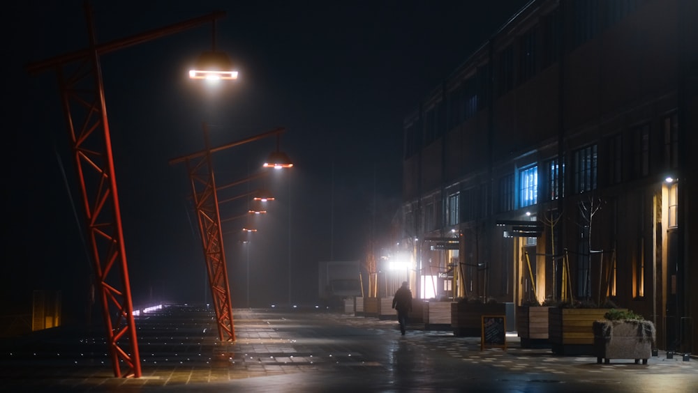 a person walking down a street at night