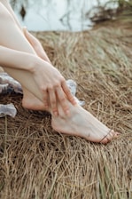 a woman's bare legs and bare feet sitting on the ground