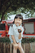 A smiling child holding a colorful bottle during a community outreach event.