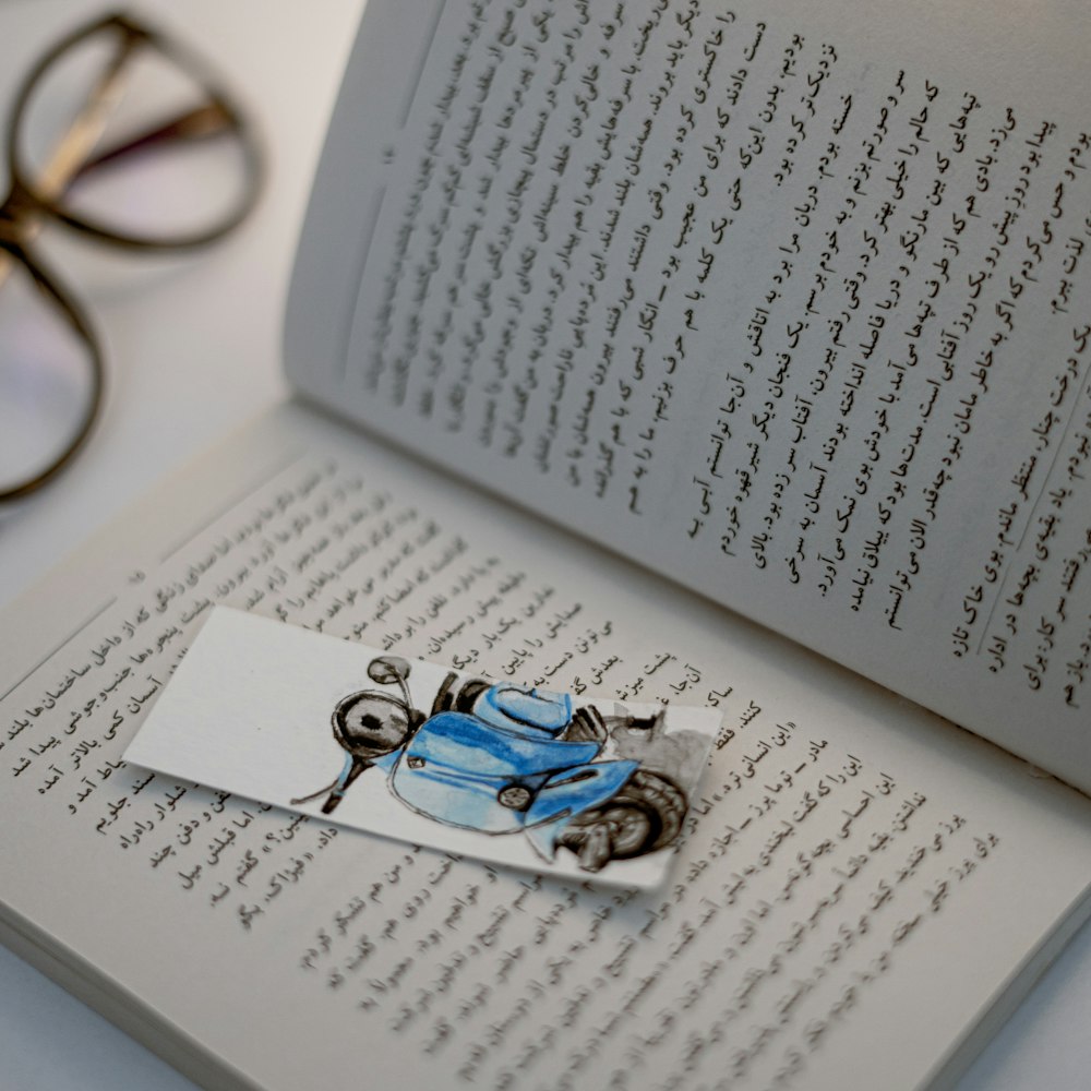 a book with a blue car on it next to a pair of glasses