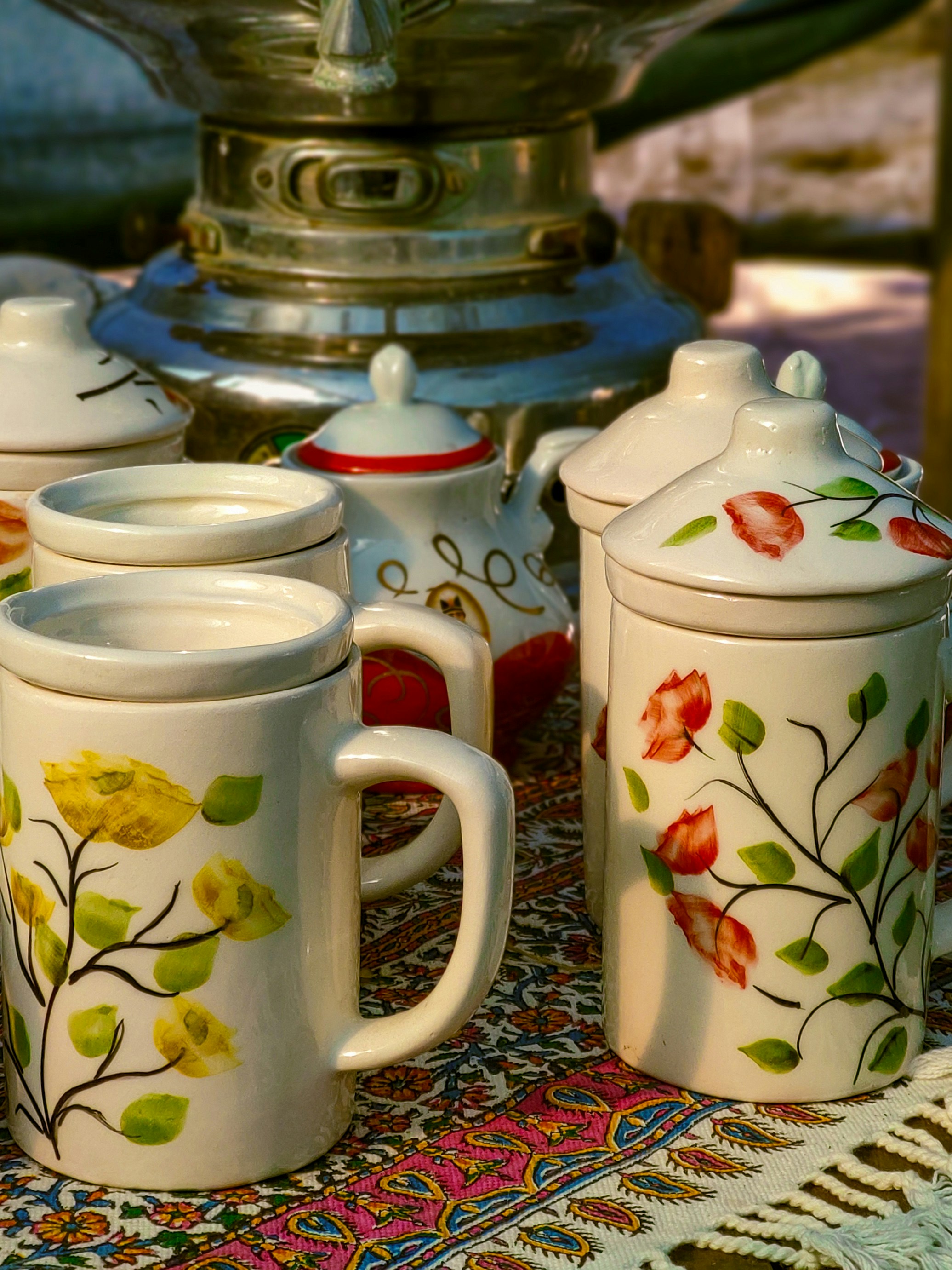 a table topped with three coffee cups and a tea pot