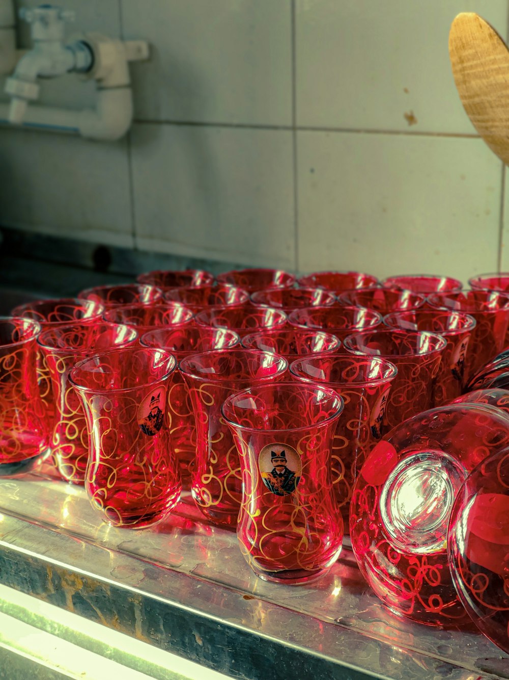 a bunch of red glass cups sitting on a counter