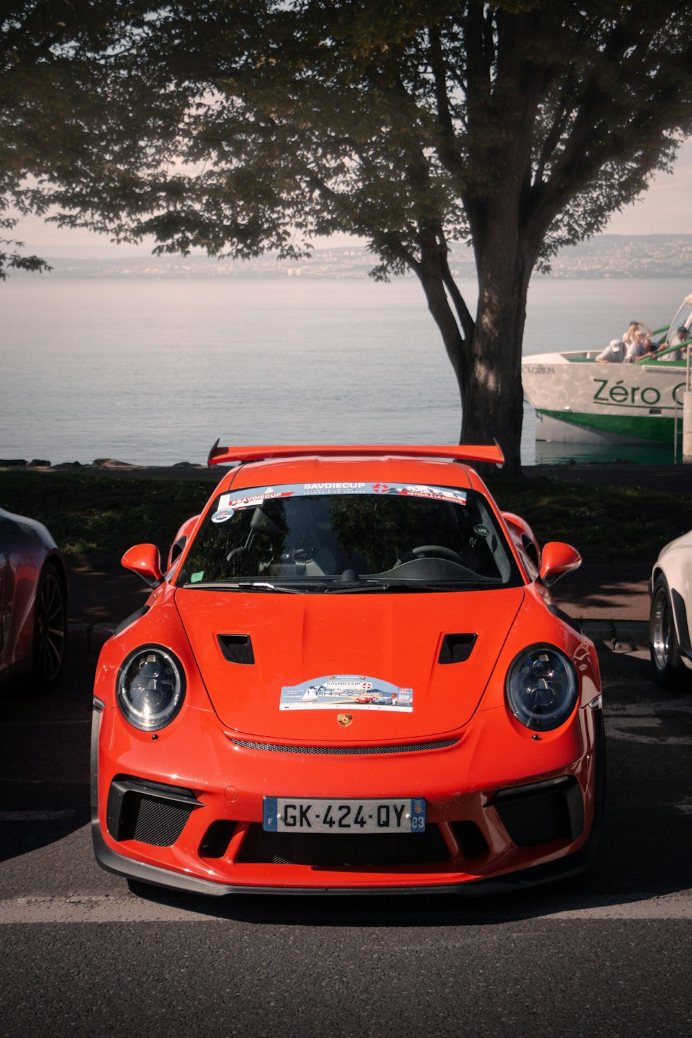 a red sports car parked next to a tree