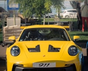 a yellow sports car driving down a street