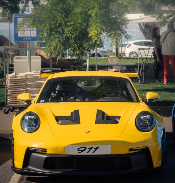 a yellow sports car driving down a street