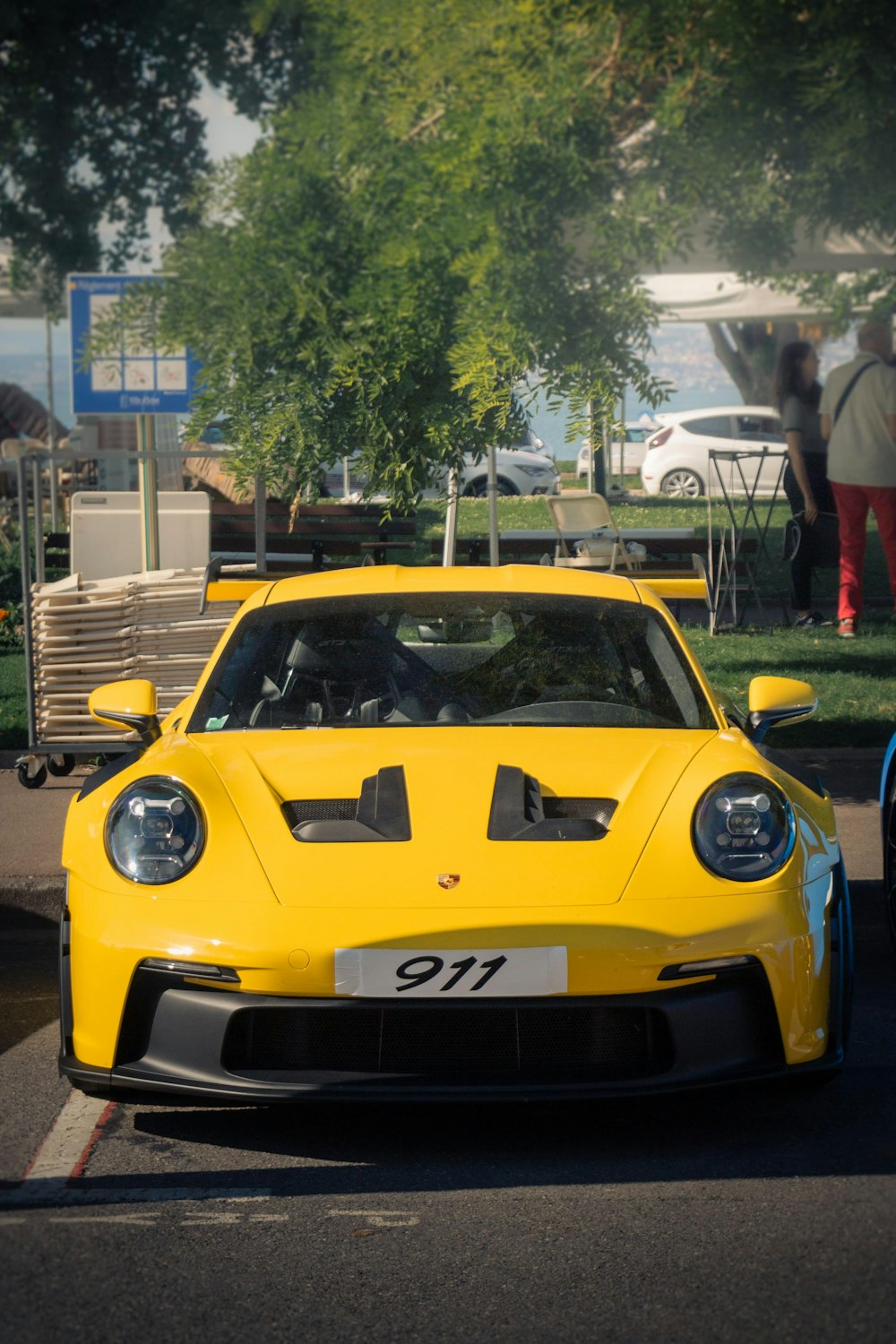 a yellow sports car driving down a street