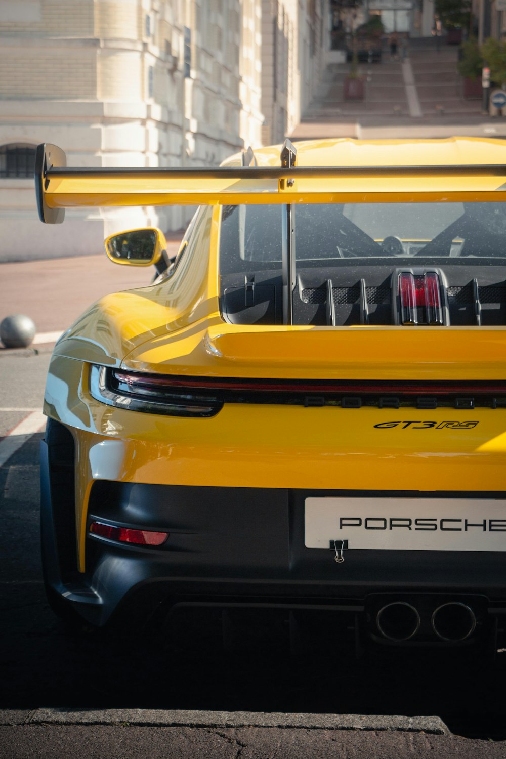 a yellow sports car parked on the side of the road