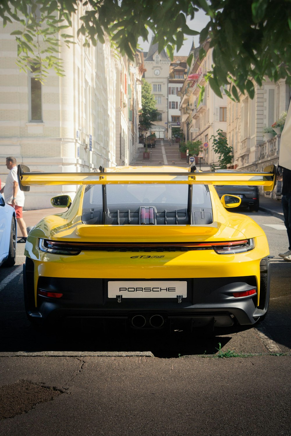 a yellow sports car parked on the side of the road