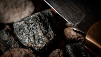 Close-up of a diamond core bit resting on rugged rock, highlighting its sharp cutting edges.