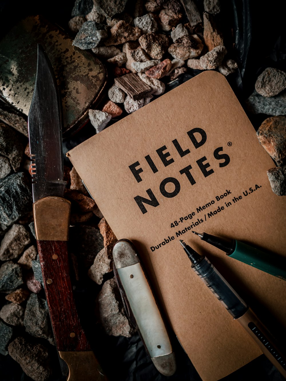 a field notes sitting on top of a pile of rocks