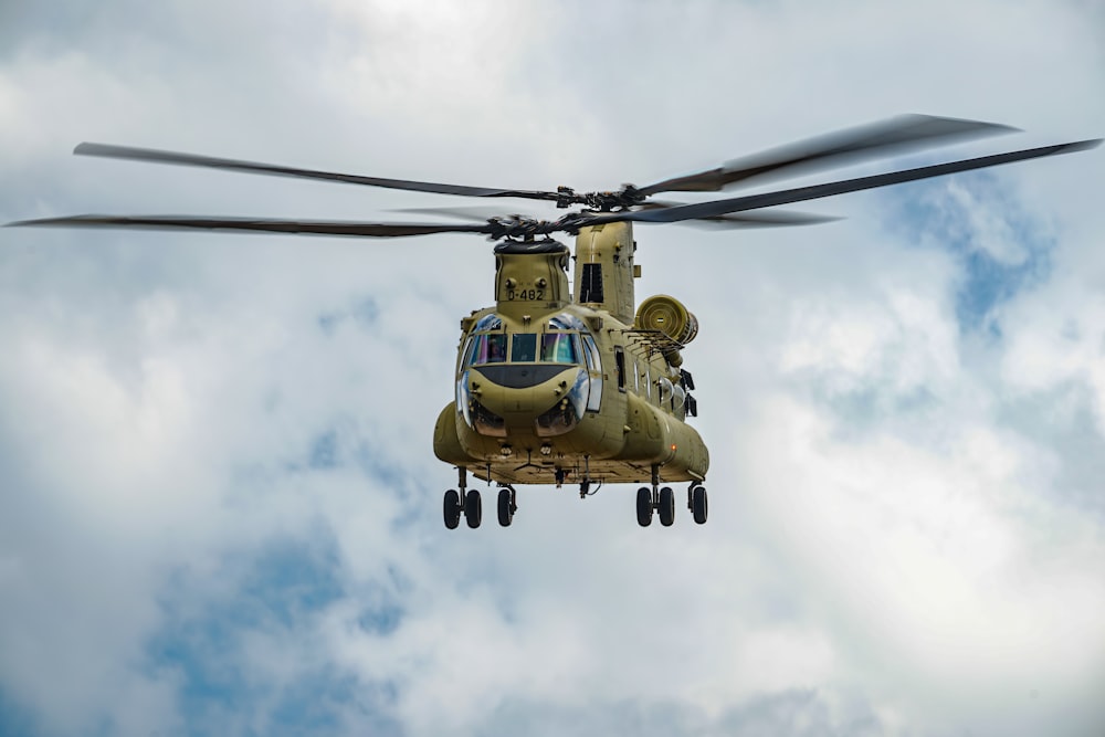 a helicopter flying through a cloudy blue sky