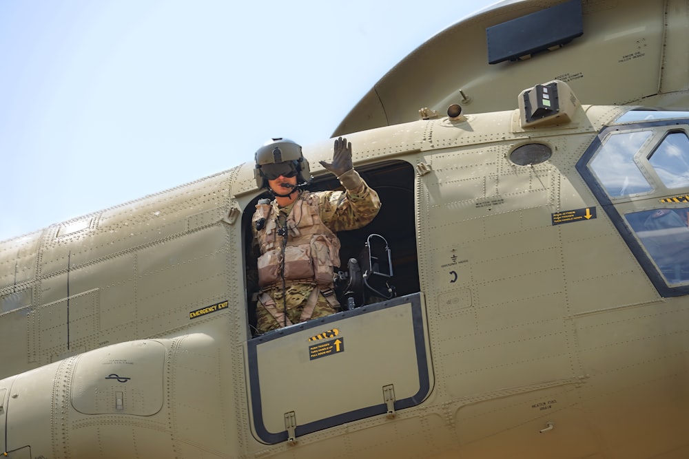 Un homme assis dans le siège du pilote d’un avion militaire