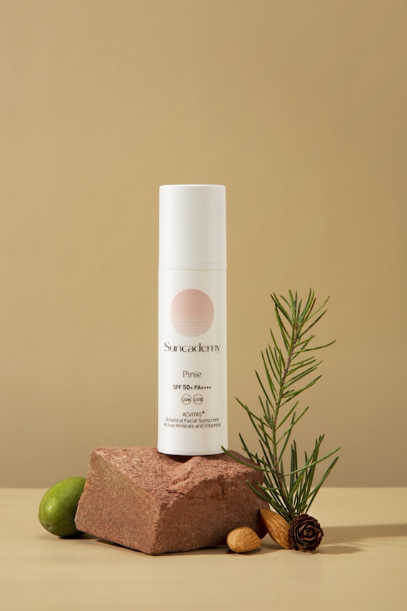 a bottle of deodorant sitting on top of a rock next to a