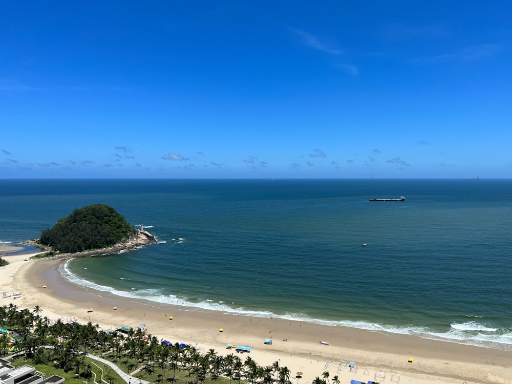 an aerial view of a beach with a boat in the water